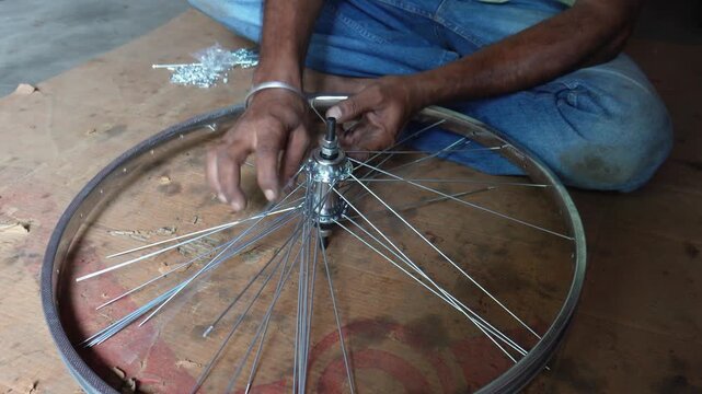 Technician lacing bicycle wheel spokes