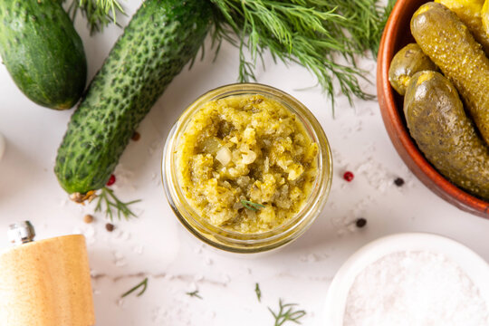Homemade Dill Pickle Relish, tasty cucumber pickle relish condiment, with fresh cucumbers, pickles, dill, onions and spices copy space