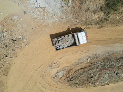 Dump truck carrying construction debris on dirt road