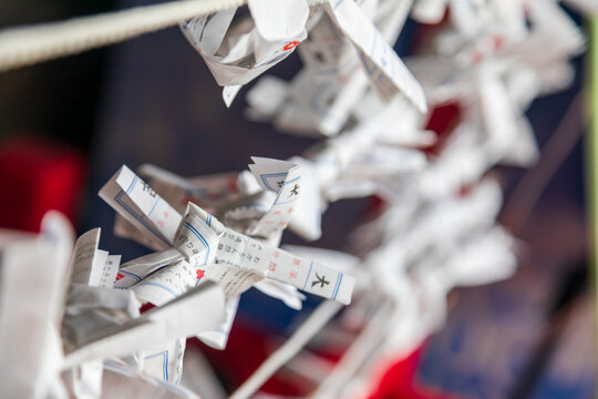 A close-up captures traditional white paper tags carrying wishes, tied to ropes.