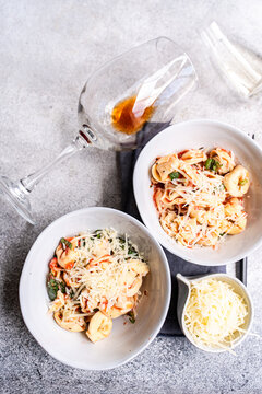 Top view of tortellini with tomato sauce, basil and wine