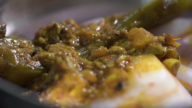 Detailed macro shot of traditional Indian mango pickle showcasing rich texture and vibrant colours.