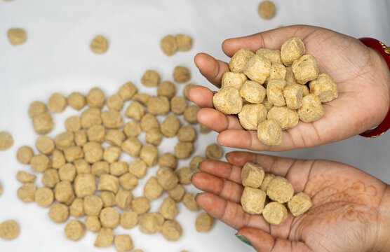Close up of woman hand holding a handful of raw dry soya chunks over a white background. plant based protein rich food. healthy food concept.