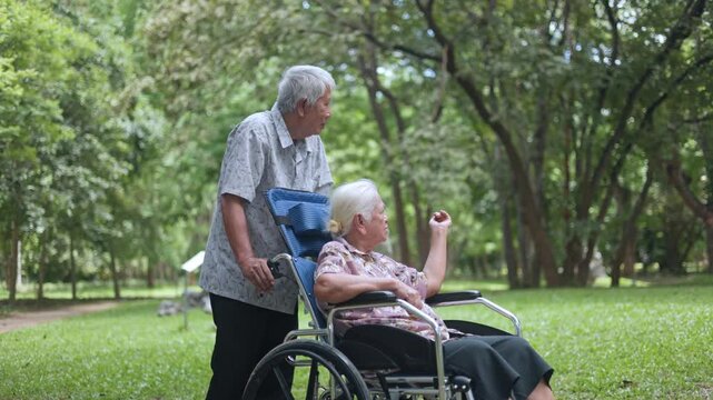 Helpful young man gently comforting his senior handicapped mother who relaxes in a blue wheelchair, expressing warm family emotions and professional caregiving in nature.