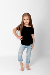 Fototapeta premium Full length portrait of cute little girl posing in black t-shirt with love more text and ripped jeans on white background