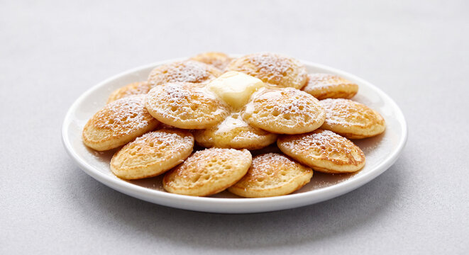 Fresh Dutch Poffertjes Mini Pancakes with Powdered Sugar and Melting Butter