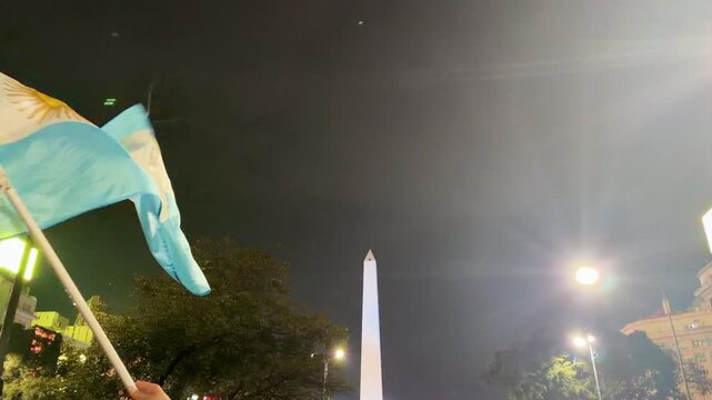 BUENOS AIRES, ARGENTINA - JULY 2026: Argentine football supporters gathered at the Obelisco waving flags and cheering after winning the world cup semifinal.