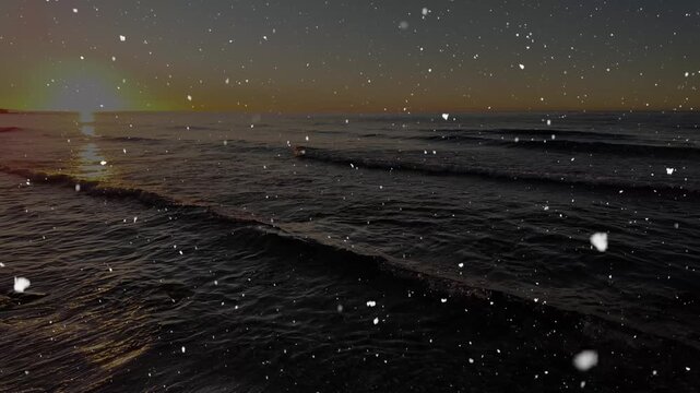 Snow falling over a calm sea at sunrise with gentle waves and golden morning light.