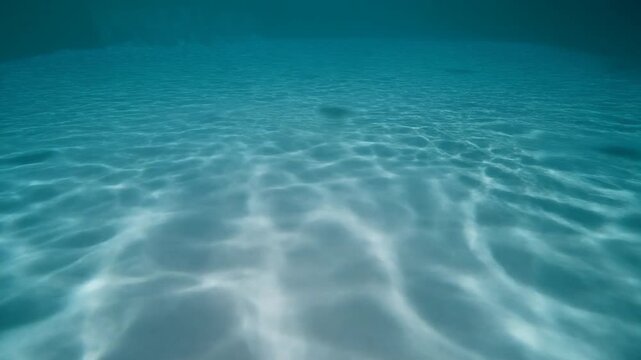Underwater caustic light patterns shimmering on sandy ocean floor in this beautiful looping motion video clip
