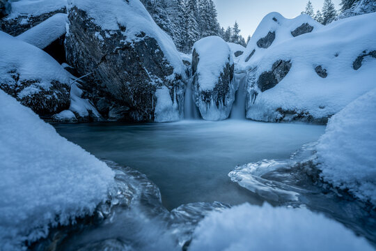 Frozen waterfall and ice pool in Rosenlaui, Switzerland winter
