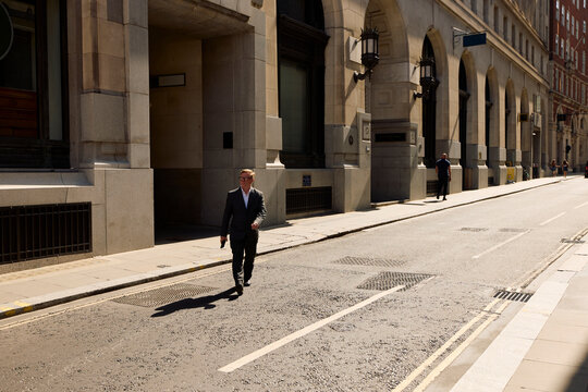 Businessman crosses the street in central London.