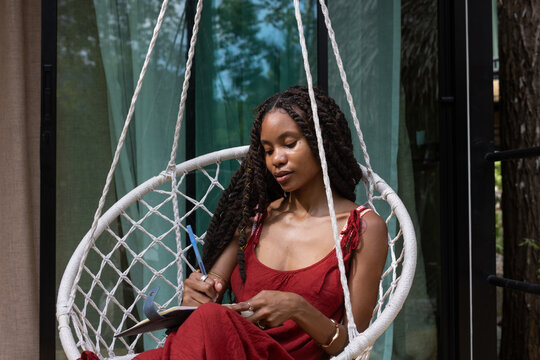 Woman Journaling in Hanging Chair, Mindfulness, write in notebook