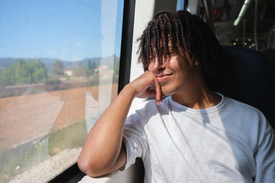 A Young Man Sits on a Train and Gazes out the Window. Copy space