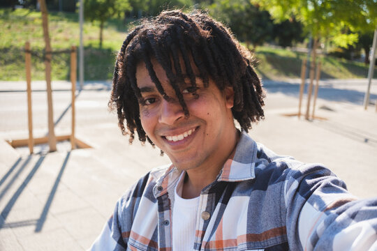 Young Man Takes Selfie in Public Park on Sunny Day