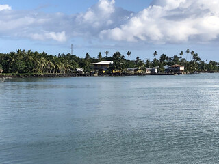 Fototapeta premium Samoan coastal village beneath dramatic tropical storm clouds