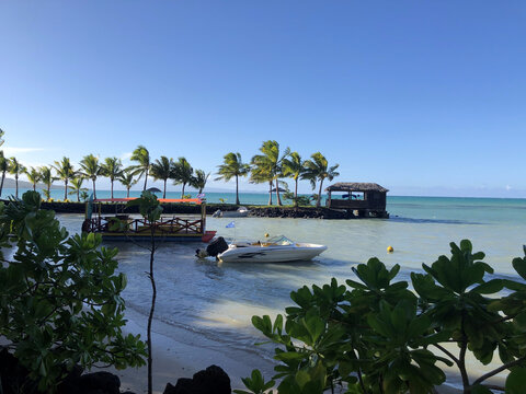 Speedboat and pontoon boat anchored in clear tropical shallows