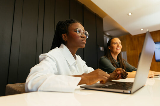 Young woman working on laptop in meeting