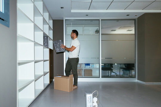 Man organizing documents on shelf in office relocation