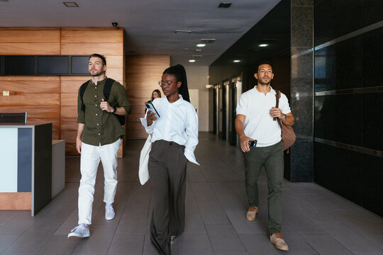 Diverse business people walking in modern lobby