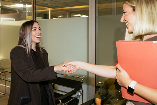 Businesswomen shaking hands after successful office meeting
