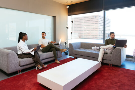 Diverse colleagues collaborating in modern office lounge area