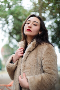 Stylish woman looking up in park