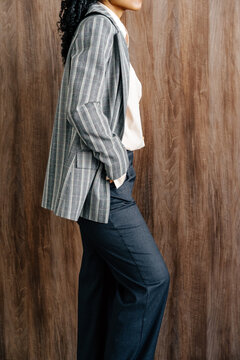 Anonymous Person  in Plaid Blazer Standing Against Wooden Wall