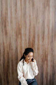 Businesswoman Talking on Smartphone Against Wooden Wall