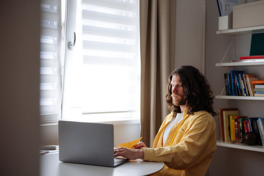 Man Working on Laptop in Bright Home Office