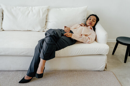 Overworked Businesswoman Napping on Sofa After Demanding Workday