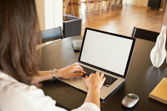 Crop of anonymous woman using laptop at office