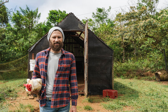 Farmer holding chicken at sustainable agriculture farm