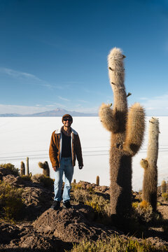 Traveler posing on cactus-covered island in Bolivia