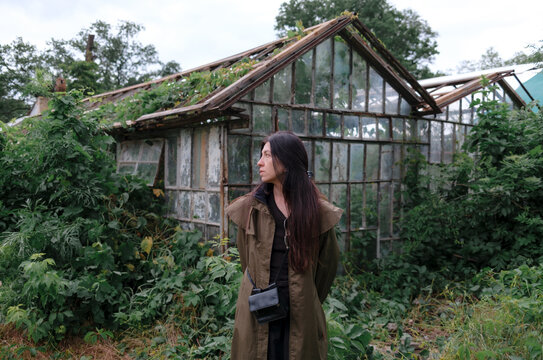 Woman standing near greenhouses in a botanical garden