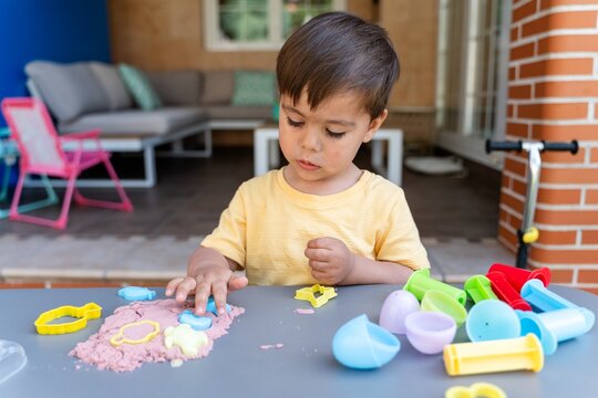 Boy Pressing Sand Into Molds