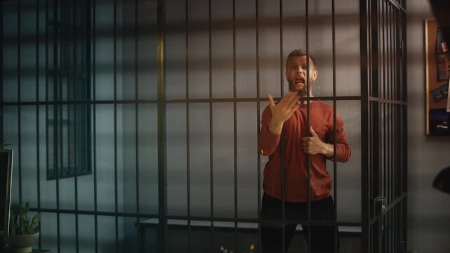 Angry male inmate shouting at a police officer through jail cell bars