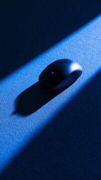A sleek black computer mouse in blue light.
