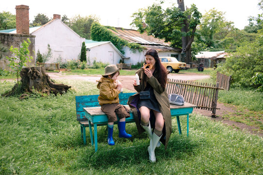Mother and son enjoying a snack together on a park bench
