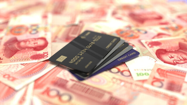 Black credit cards stacked on top of chinese yuan renminbi banknotes.