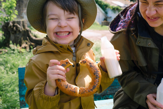 Mother and son enjoying a snack together on a park bench