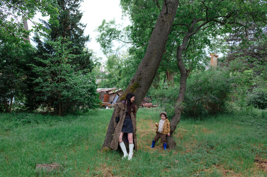 Mother and son standing by trees in a botanical garden