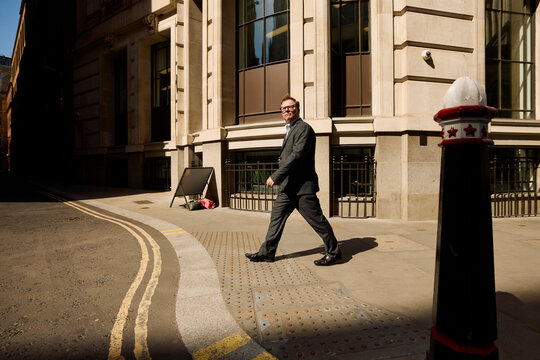 Businessman strolls through an alley in central London.