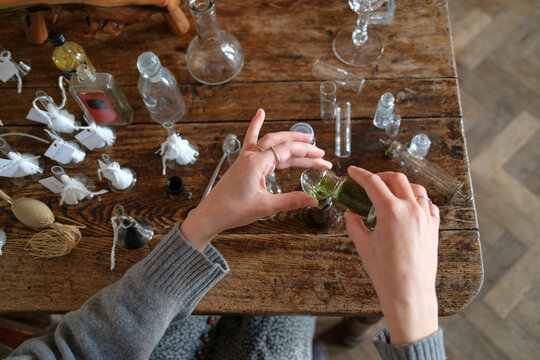 Hands of a perfumer blending fragrance ingredients in a studio