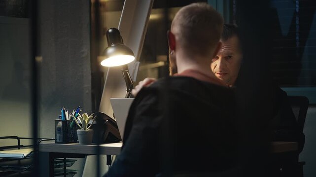 Middle-aged police officer questioning a male witness during an investigation