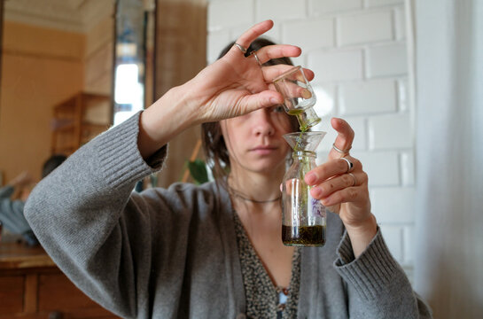 Hands of a perfumer blending fragrance ingredients in a studio