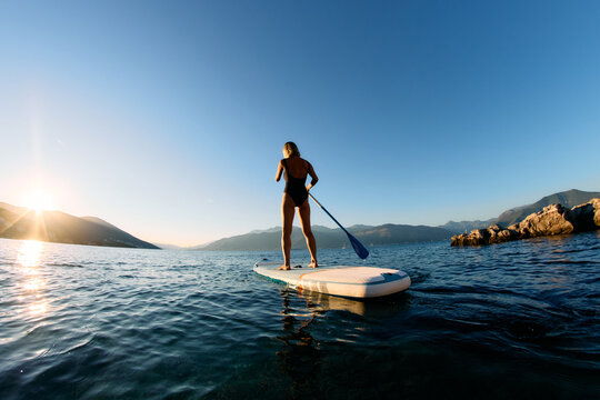 Woman SUP paddle boarding on sea