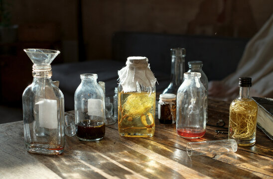 erfume bottles and glass vessels arranged on studio table in natural l