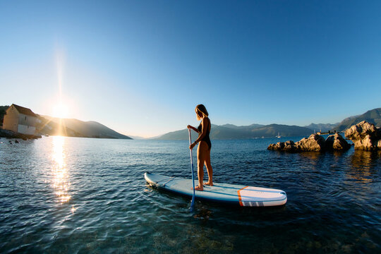 Woman SUP paddle boarding on sea