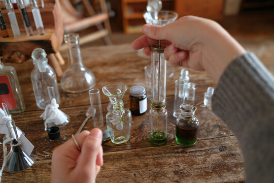 Hands of a perfumer blending fragrance ingredients in a studio