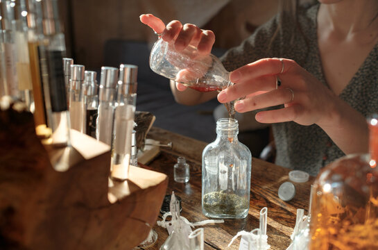 Hands of a perfumer blending fragrance ingredients in a studio